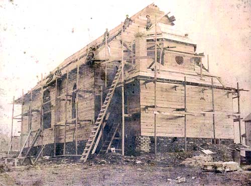 The Catholic Church under construction, circa 1909 (taken form the back). Earl Nupp, the general contractor, is third from the left (sitting on the scaffolding).
